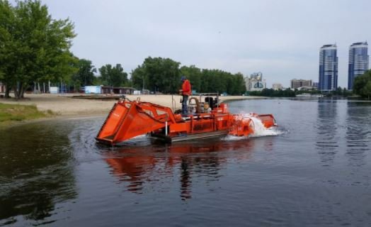 Коммунальщики с помощью спецтехники за лето вывезли с пляжей Киева 270 тонн водорослей и камыша